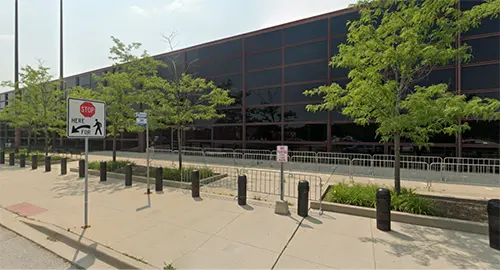 Reflective glass building with surrounding trees.