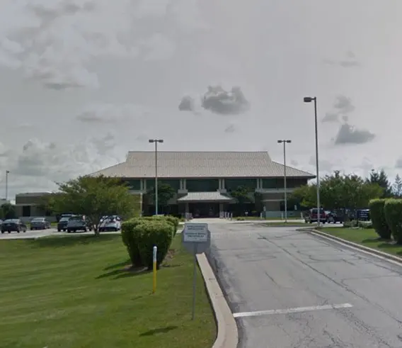 Large building with landscaped entrance and parking.