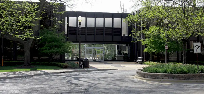 Modern building surrounded by green foliage.